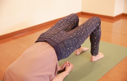 マットの上で仰向けになって腰を上げる女性